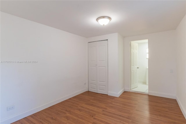 unfurnished bedroom with a closet and hardwood / wood-style flooring