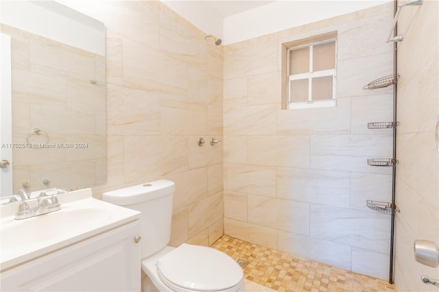 bathroom featuring tiled shower, vanity, and toilet