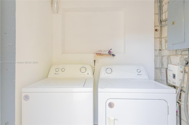 laundry area with electric panel and washing machine and clothes dryer