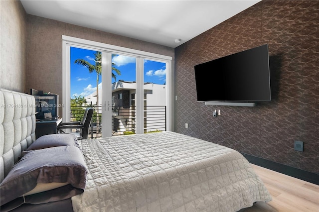 bedroom with access to exterior and wood-type flooring