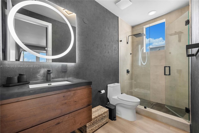 bathroom with hardwood / wood-style floors, vanity, a shower with shower door, and toilet