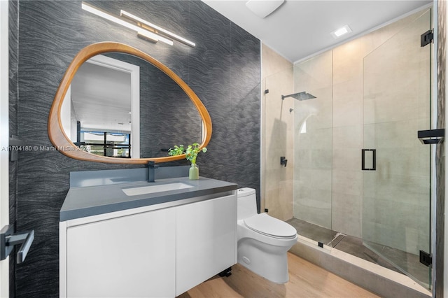 bathroom with an enclosed shower, vanity, toilet, and wood-type flooring