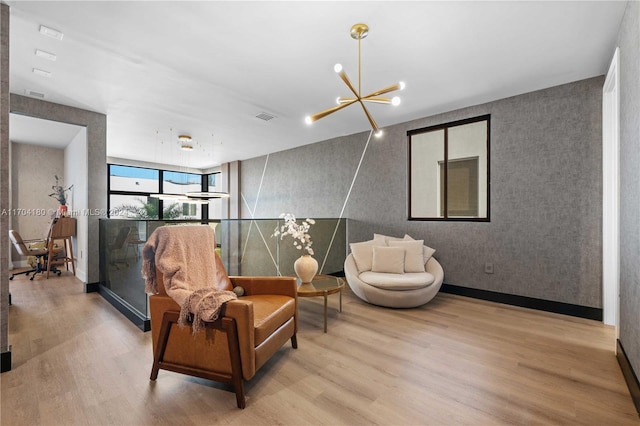 sitting room with light hardwood / wood-style floors and an inviting chandelier