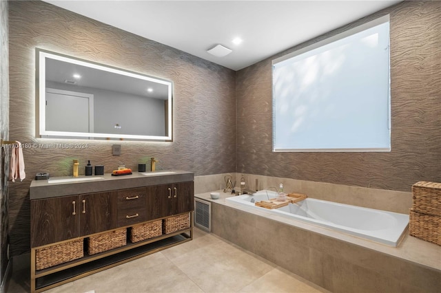 bathroom with tile patterned flooring, vanity, and tiled bath