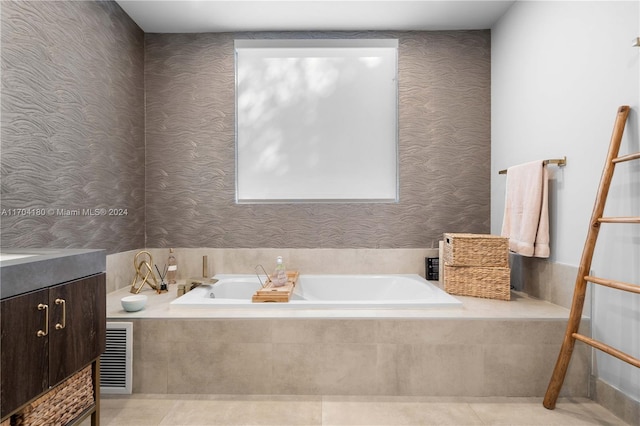 bathroom featuring tile patterned floors, a relaxing tiled tub, and vanity