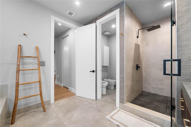 bathroom featuring toilet, tiled shower, and a bidet