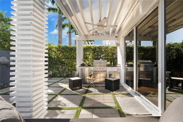 view of patio with an outdoor kitchen, ceiling fan, and a grill