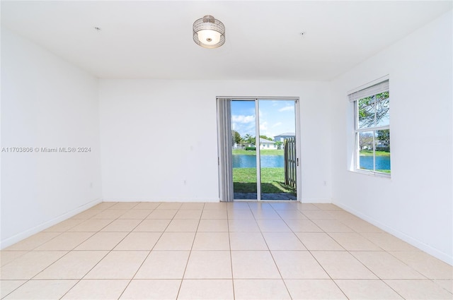 tiled empty room featuring a water view