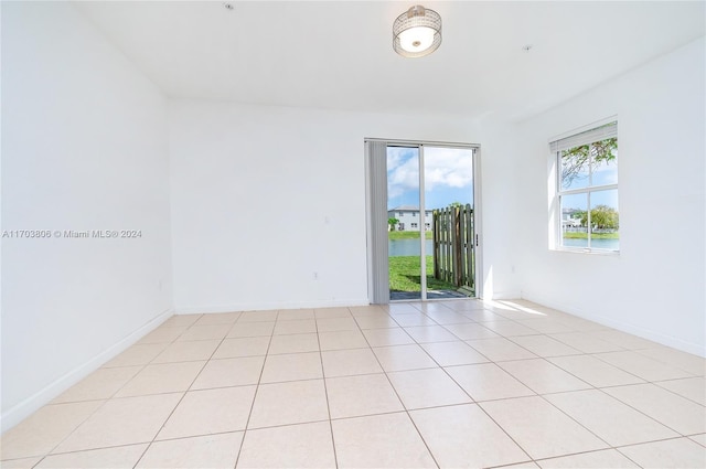 tiled spare room featuring a water view