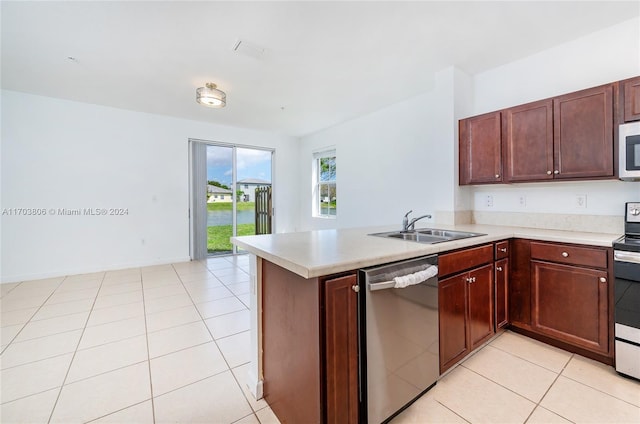 kitchen featuring kitchen peninsula, light tile patterned floors, stainless steel appliances, and sink