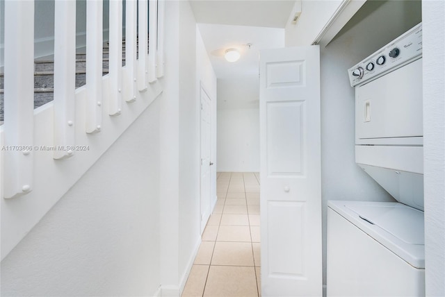 washroom featuring stacked washing maching and dryer and light tile patterned floors