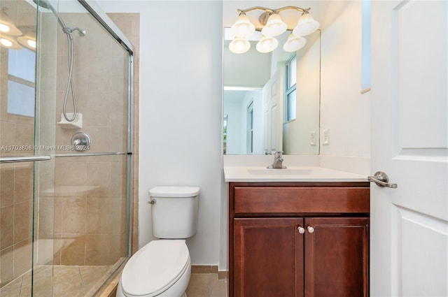 bathroom with vanity, toilet, and a shower with door