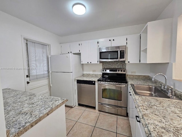 kitchen featuring white cabinets, appliances with stainless steel finishes, light tile patterned floors, and sink