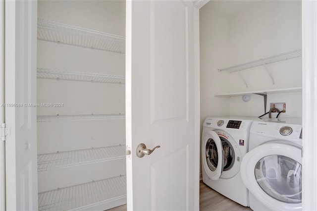 washroom featuring separate washer and dryer and light hardwood / wood-style flooring