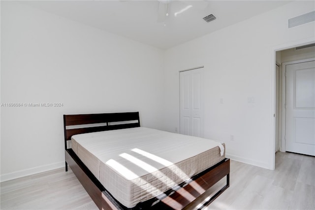 bedroom with light hardwood / wood-style floors and a closet