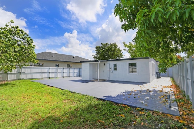 rear view of property featuring a patio and a lawn