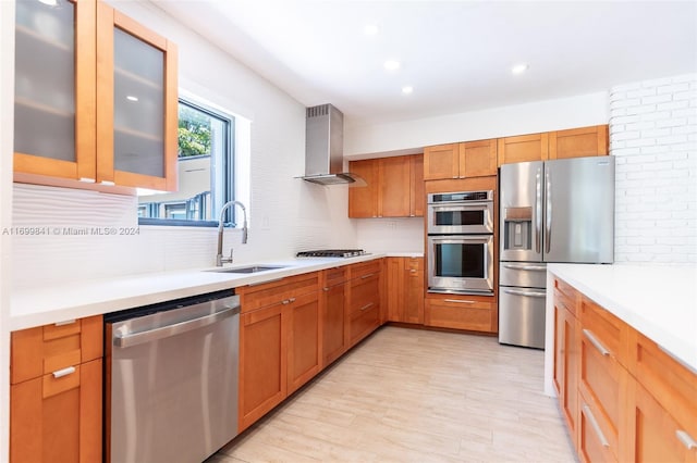 kitchen with wall chimney exhaust hood, sink, stainless steel appliances, and tasteful backsplash