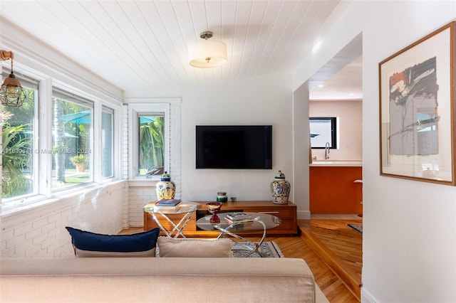 living room with hardwood / wood-style floors and brick wall