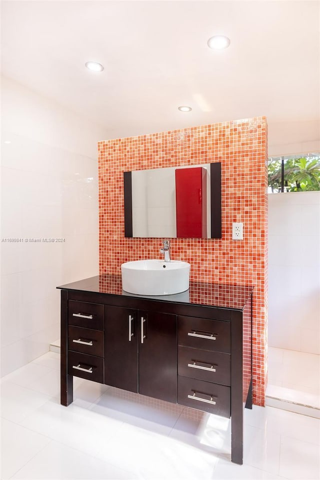 bathroom with tile patterned flooring, vanity, and tile walls