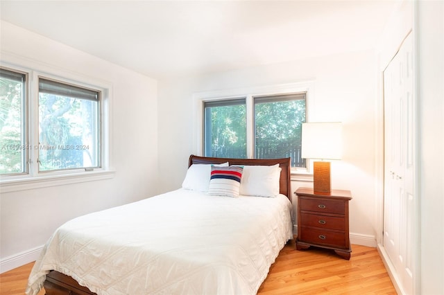 bedroom with light wood-type flooring and multiple windows