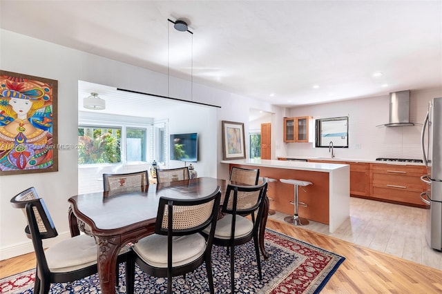 dining area with light hardwood / wood-style flooring and sink