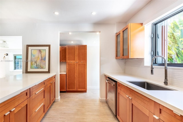 kitchen with dishwasher, sink, a wealth of natural light, and light hardwood / wood-style flooring