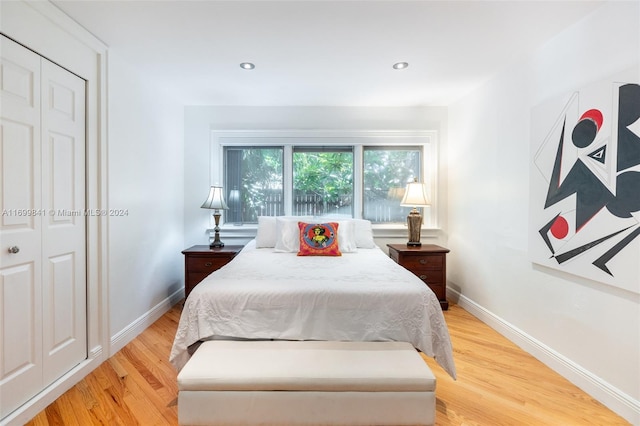 bedroom with light wood-type flooring and a closet