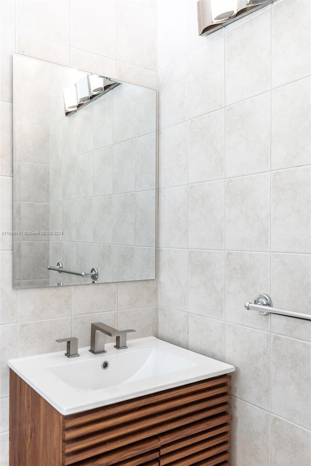 bathroom featuring vanity and tile walls