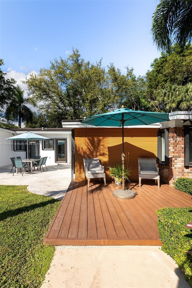 wooden terrace featuring a patio area and a yard