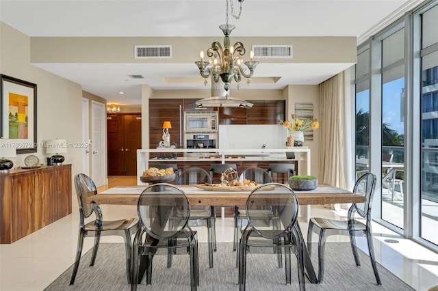 dining space featuring light tile patterned floors, visible vents, a wall of windows, and a notable chandelier