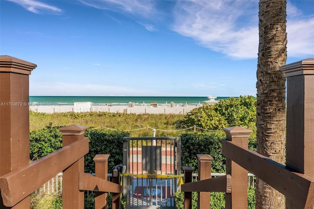 view of water feature with a beach view and a gate