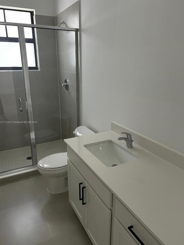 bathroom featuring vanity, toilet, and an enclosed shower