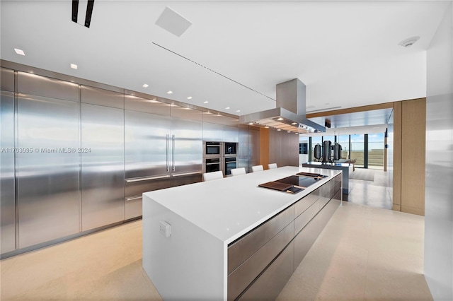 kitchen featuring black electric stovetop, a spacious island, island exhaust hood, and double oven