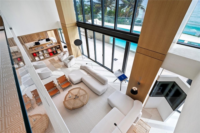 living room featuring a water view and a towering ceiling