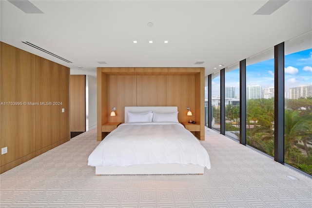 carpeted bedroom featuring access to outside, floor to ceiling windows, and wood walls