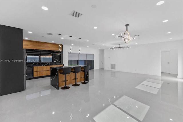 kitchen with a kitchen breakfast bar, hanging light fixtures, and sink