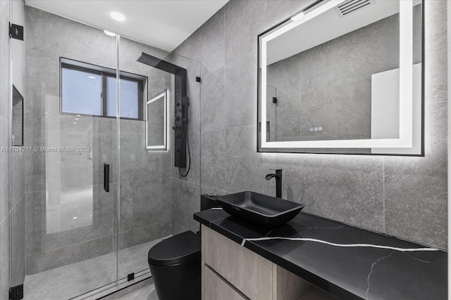 bathroom featuring vanity, toilet, an enclosed shower, and tile walls