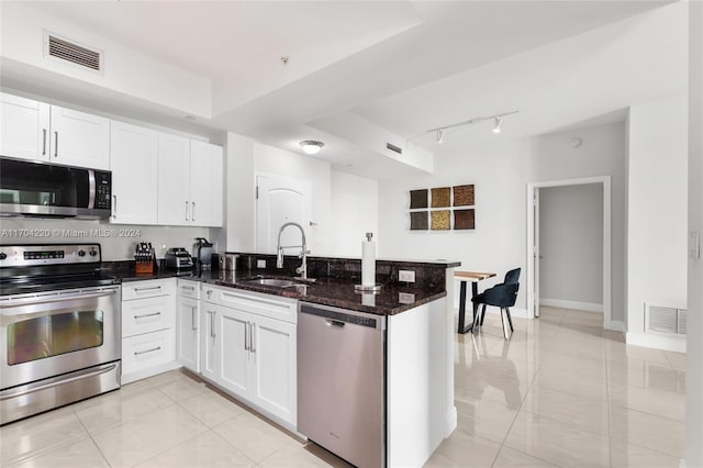 kitchen featuring white cabinetry, sink, appliances with stainless steel finishes, and dark stone counters