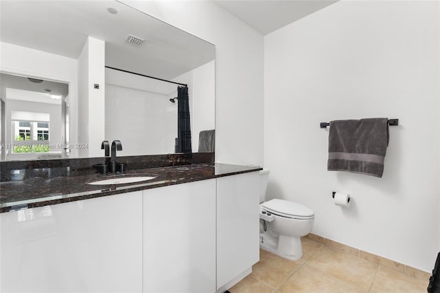 bathroom with tile patterned flooring, vanity, curtained shower, and toilet