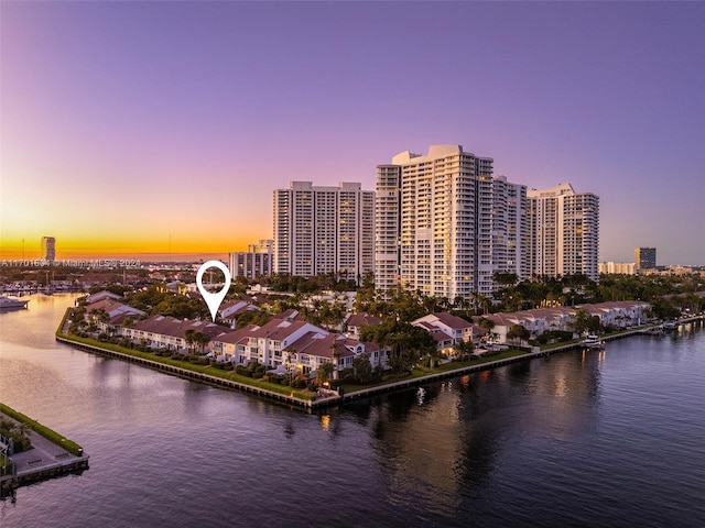 aerial view at dusk featuring a water view