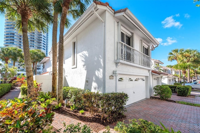 view of side of home featuring a balcony and a garage