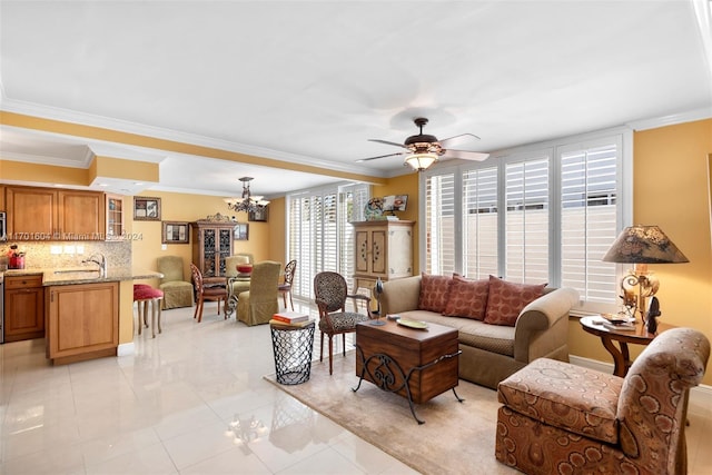 tiled living room with crown molding, sink, and ceiling fan with notable chandelier