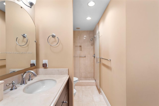 bathroom featuring tile patterned floors, vanity, toilet, and a tile shower