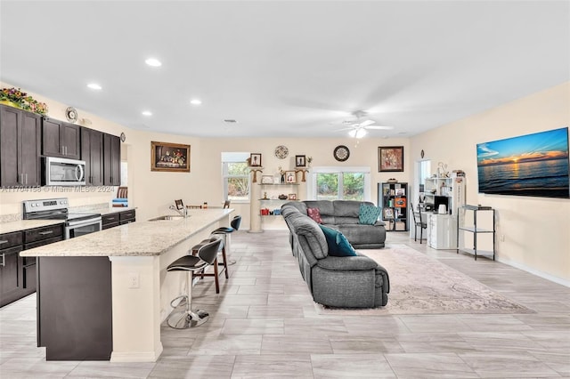 living room with ceiling fan and sink