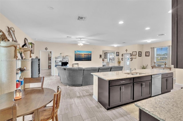 kitchen featuring dishwasher, sink, light hardwood / wood-style flooring, an island with sink, and dark brown cabinets