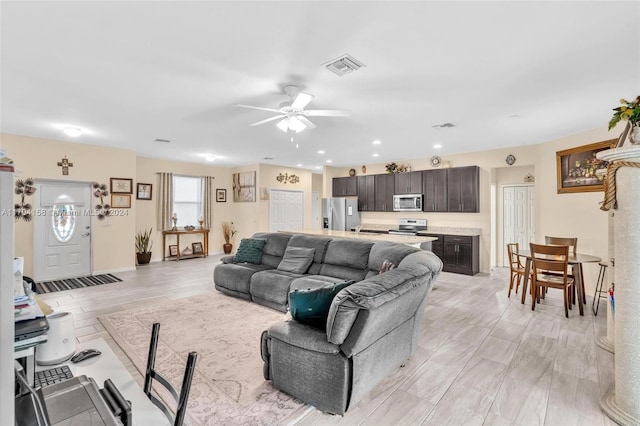 living room featuring ceiling fan and light hardwood / wood-style flooring