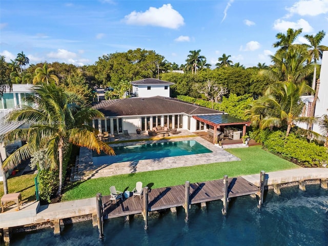 rear view of property with a lawn, a water view, and a patio