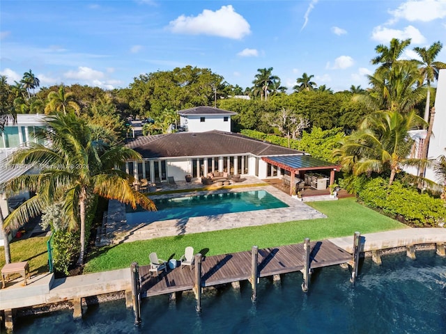 9301 N Bayshore Dr, Miami Shores, FL 33138 - rear view of property with an outdoor pool, a yard, a patio, and a water view