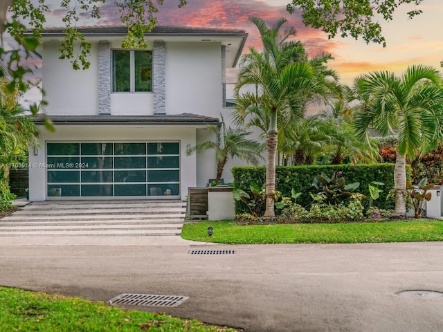 9301 N Bayshore Dr, Miami Shores, FL 33138 - view of front of home with stucco siding, driveway, and an attached garage