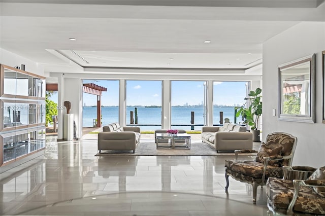 living room featuring a water view and a tray ceiling